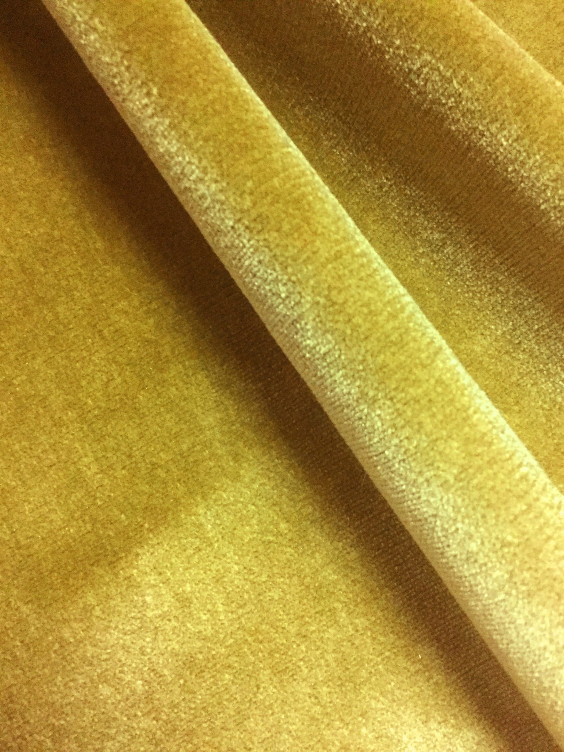 Detaliu material pentru draperie de catifea lucioasă galbenă cu aspect elegant